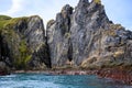 Steep cliffs with moss and algal, caves and seashore in South Georgia Royalty Free Stock Photo