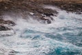 Seashore during a storm. Sea with blue water and big waves, waves hitting the rocks with big splashes Royalty Free Stock Photo