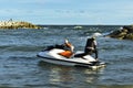 On the seashore there is a woman and a dog riding a water scooter, summer vacation in the tropical sea,