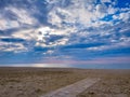 On the seashore. Under a sky filled with clouds penetrating by the setting sun. Royalty Free Stock Photo