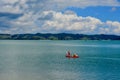 Seashores of New Zealand; beautiful seascape, bright blue ocean, and some people far away enjoying water activities.