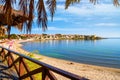 Seaside landscape - view from the cafe to the sandy beach with umbrellas and sun loungers Royalty Free Stock Photo