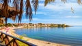 Seaside landscape - view from the cafe to the sandy beach with umbrellas and sun loungers Royalty Free Stock Photo