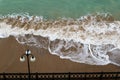 sea promenade with lantern and sand beach in stormy weather with waves Royalty Free Stock Photo