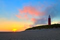 Seaside with sand dunes and lighthouse at sunset Royalty Free Stock Photo