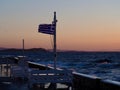 Seaside Tables and Greek Flag at Sunset Royalty Free Stock Photo