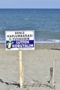 At the seaside, there is a warning sign "Let's protect the sea turtle nest".