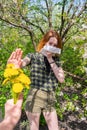 Season allergy to flowering plants pollen. Young woman with paper handkerchief covering her nose in garden and doing Royalty Free Stock Photo