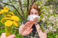 Season allergy to flowering plants pollen. Young woman with paper handkerchief covering her nose in garden and doing Royalty Free Stock Photo