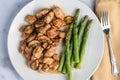 season chicken bites top with mushrooms with asparagu