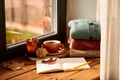 sketchbook, autumn leaf and coffee on window sill