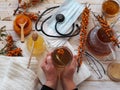 An elderly woman is hands hold a cup of sea buckthorn tea. The concept of protecting and treating flu and colds with folk remedies Royalty Free Stock Photo