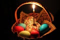 Easter cake, lighted candle and painted eggs in the basket Royalty Free Stock Photo