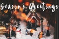 Season`s greetings text on Little Christmas city in miniature wi Royalty Free Stock Photo