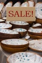 Season sale, black friday and shopping concept. Sign with the inscription Sale. Ceramic dishes in the background. Space for text Royalty Free Stock Photo