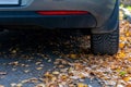 Season tire change. Car with new winter tires on the road for autumn leaves. Safety on a slippery autumn road.