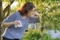 Seasonal allergies, woman with nasal wipe, sneezing, wiping nose outdoor