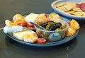 Seasonal appetizer platter with olives, cheese, meat and oranges