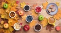 Seasonal autumn background. Frame of maple leaves and a cake, berries, raisins, apples, fruits, coffee and nuts over