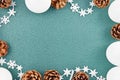 Seasonal Christmas background with white tree baubles, pine cones and star garlad forming border around empty copy space Royalty Free Stock Photo