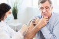 Brazilian nurse doing vaccination to senior man Royalty Free Stock Photo