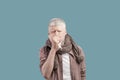 Seasonal flu. Sick albino guy blowing his nose into paper napkin, standing over studio background