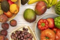 Seasonal fruits and vegetables on white table and bowls. Ivory Coast mangoes, red peppers and tomatoes, Royalty Free Stock Photo