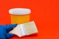 Paint, brush, gloves are placed on a red background Royalty Free Stock Photo