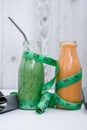 Seasonal Matcha green vegan smoothie and pumpkin carrot smoothie drink detox Breakfast with measuring tape and rubber Royalty Free Stock Photo