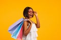 Seasonal sales. Beautiful black woman with shopping bags shouting WOW and looking at camera on orange background Royalty Free Stock Photo