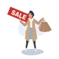 Seasonal Shopping Spree. Autumn Sale. Full-Length Stylish Woman Holding Sale Sign with Shopping Bags. Happy Shopper with Autumn