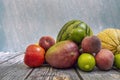 Seasonal summer fruit on a wooden table. African mango, limes, gaul melon, watermelon Royalty Free Stock Photo