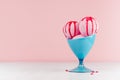 Seasonal sweet dairy dessert - pink ice cream scoops in elegant blue bowl with strawberry jam in modern stylish pastel pink.