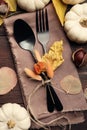 Seasonal table setting. Cutlery with pumpkins and autumn leaves on wood, flat lay Royalty Free Stock Photo