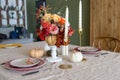Seasonal table setting with plates, flowers and candles