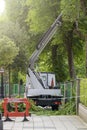 Seasonal tree pruning with a lifting work platform of hydraulic car crane. Cutting branches