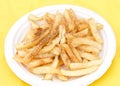 Seasoned french fries on a white paper plate