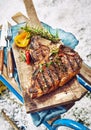 Seasoned grilled T-bone steak at a winter BBQ