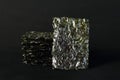 Seasoned seaweed snack. Algae sheets stacked in a pile on black background Royalty Free Stock Photo