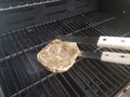 Seasoned steak on a grill with tongs