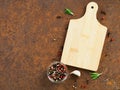 Seasoning and cutting board, garlic clove on dark rusty metal ba Royalty Free Stock Photo