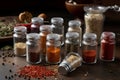 Seasoning shakers filled with every possible dried and ground herb, spice, chili and pepper, with some contents spilling out onto