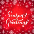 Seasons Greetings calligraphy hand lettering on red background with bokeh and snowflakes. Merry Christmas and Happy New Royalty Free Stock Photo