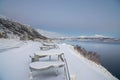 Seat at lakeside covered with snow in winter in Lofoten Islands in Norway