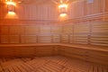 Seat in sauna room. Empty wooden steam room with stone heater. Royalty Free Stock Photo