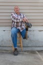 Seated amputee man resting hands on shoe of prosthetic leg