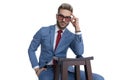 Seated attractive businessman sticking one hand in pocket