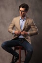 Seated business man buttoning his suit and looks to side Royalty Free Stock Photo