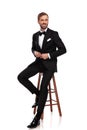 Seated businessman buttons suit and looks to side