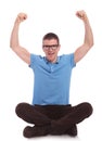 Seated casual man cheers with hands in air